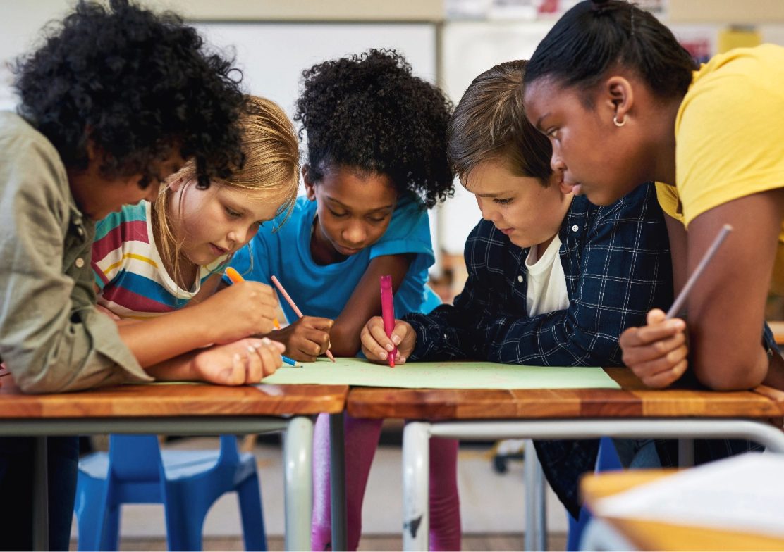 Children working together on a lesson activity at a classroom desk