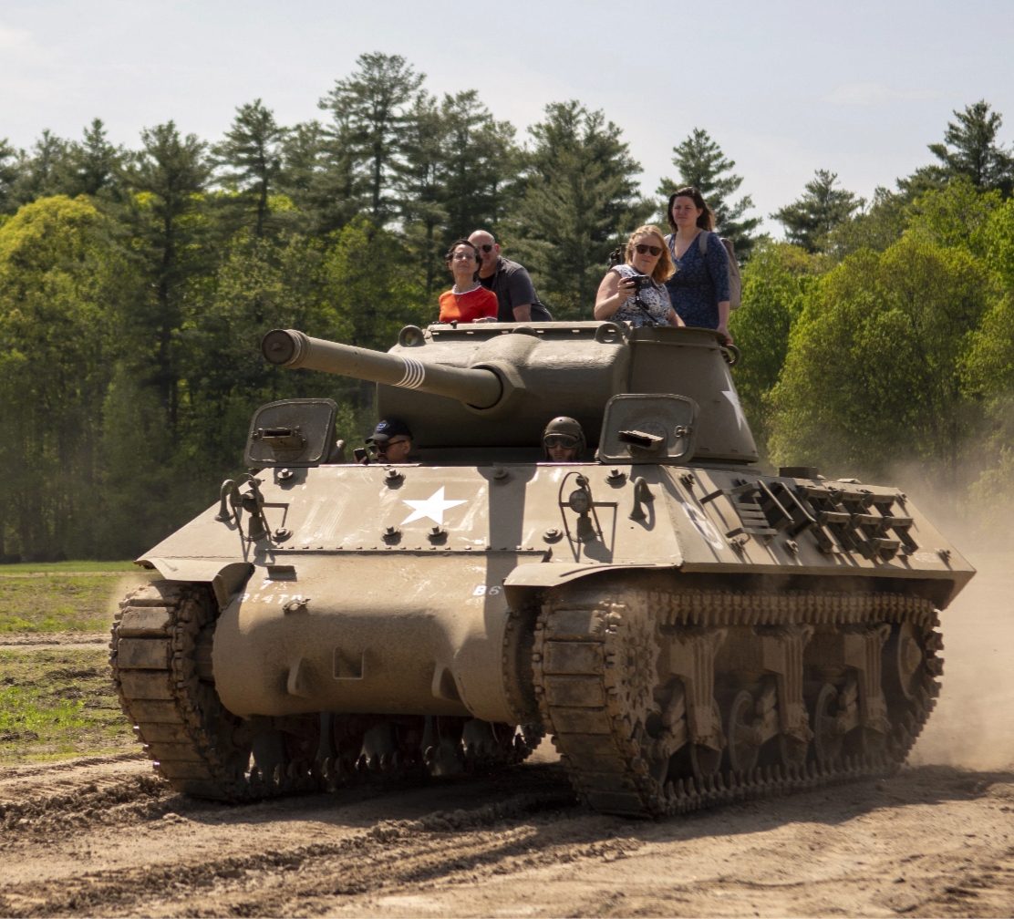Visitors riding aboard an M4 Sherman tank during a tank ride