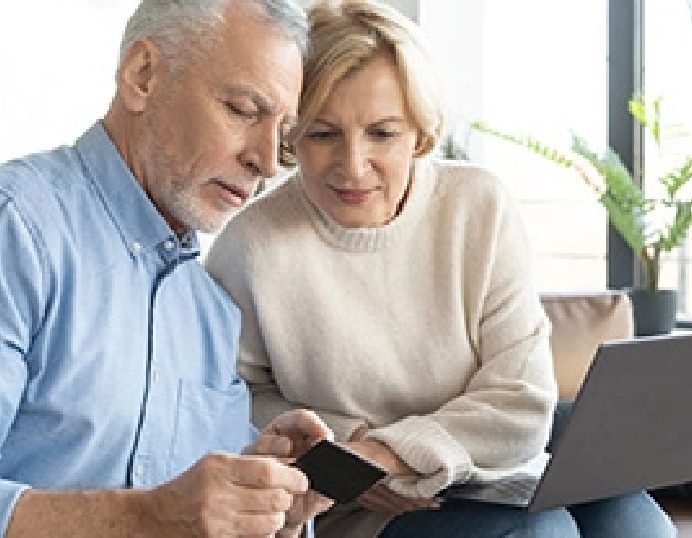 Senior couple reviewing their finances together on a laptop at home