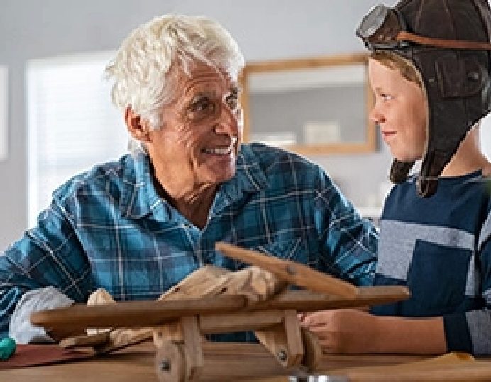 Grandfather and grandson building a wooden model airplane together