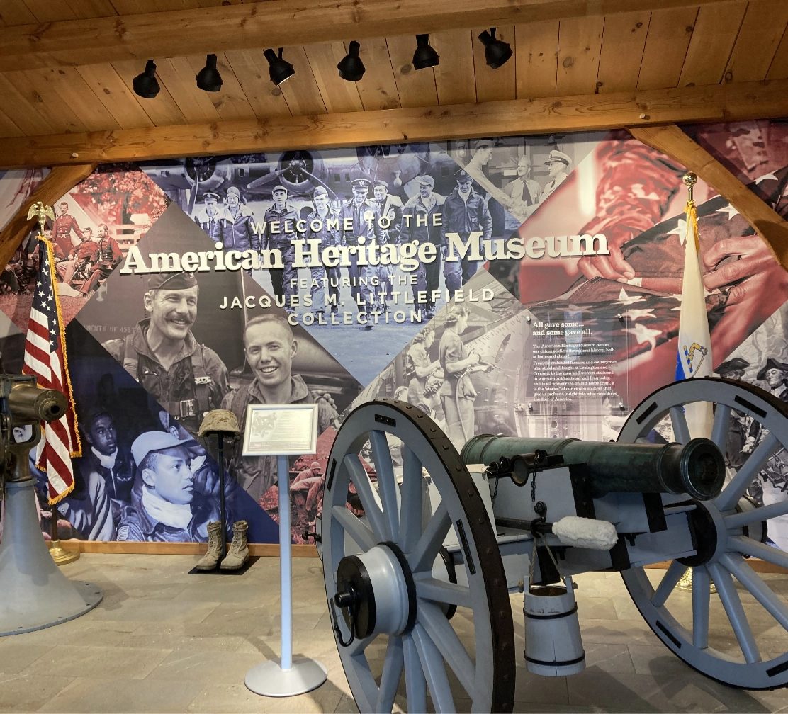 Cannon and flags in front of the Welcome to the American Heritage Museum mural